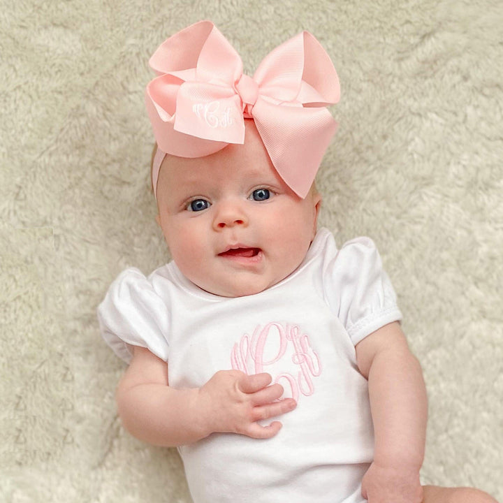 Baby girl in onesie with bow