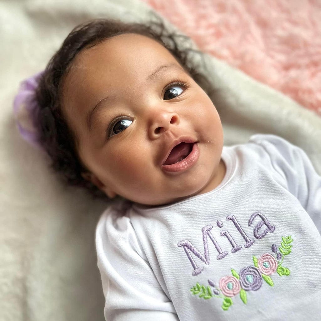 Mila smiling baby girl with floral embroidery