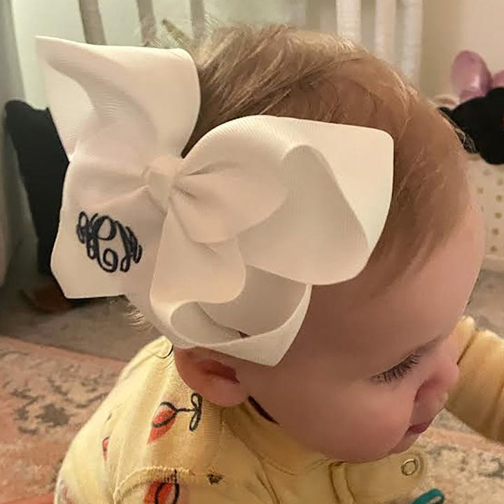 Baby with a white bow in their hair.