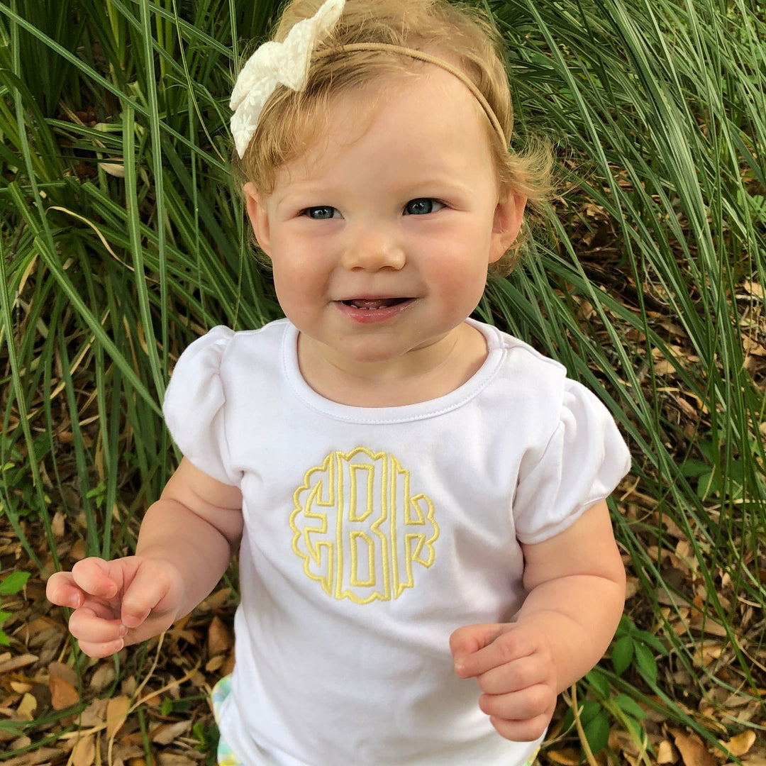 Monogrammed toddler clothes, toddler girl in a white top outdoors
