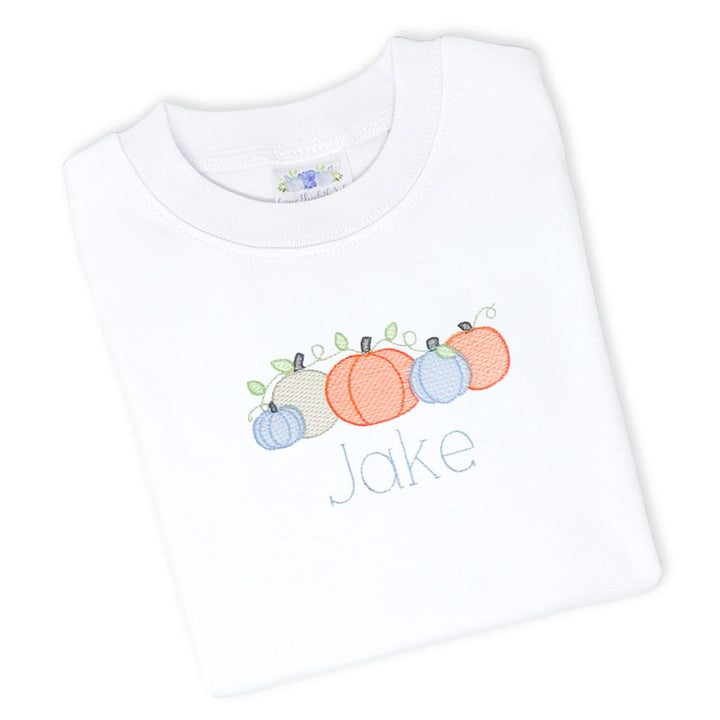 photo of a white pumpkin patch tee with orange pumpkins and a name embroidered underneath
