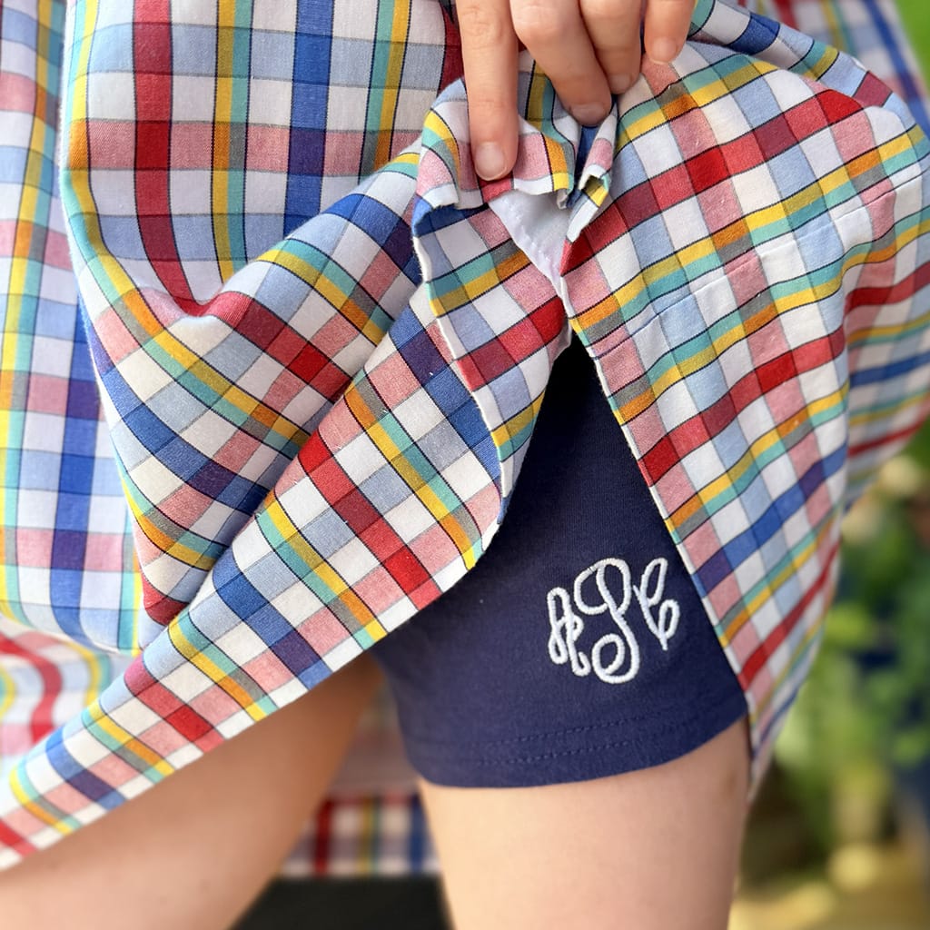 Girls Navy Blue Cartwheel Shorts with White Monogram under a plaid dress