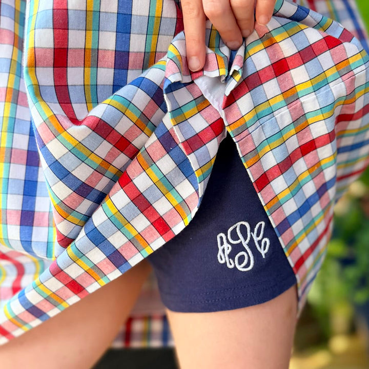 Girls Navy Blue Cartwheel Shorts with White Monogram under a plaid dress