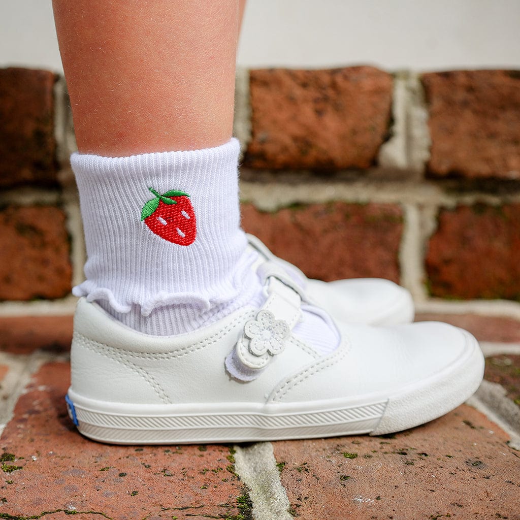 Girl's white socks with strawberry embroidery and white shoes.