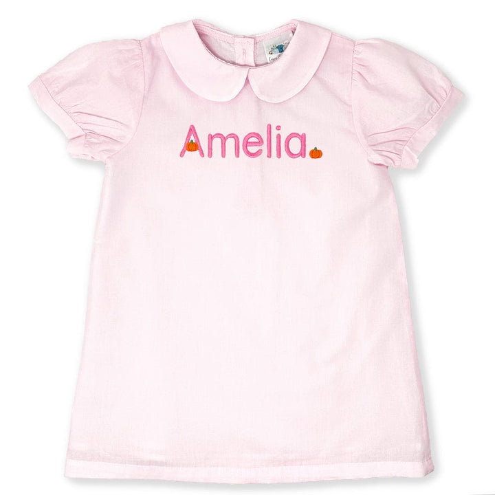 Pink dress with 'Amelia' printed on it against a white background