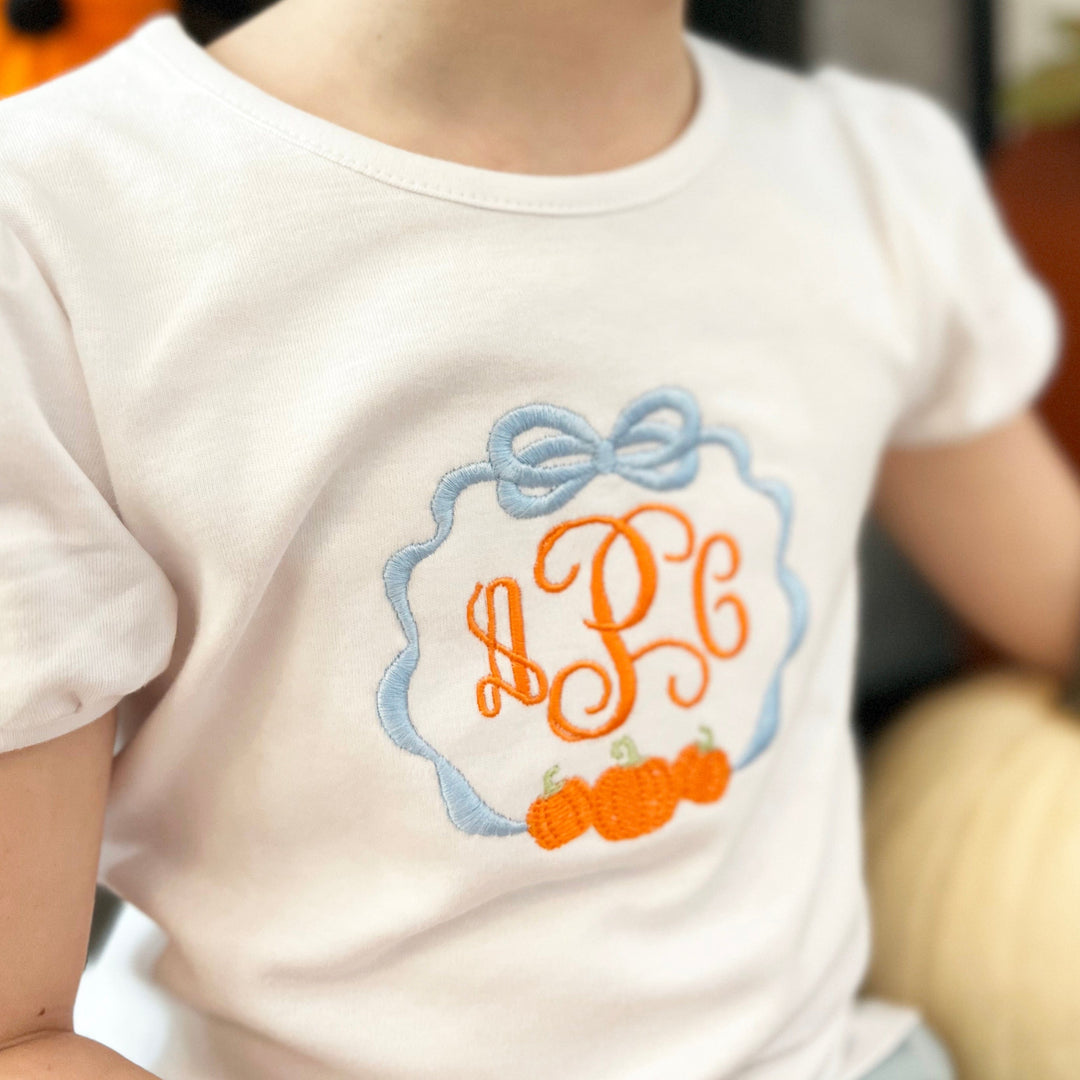 Child's shirt with embroidered pumpkin frame monogram.