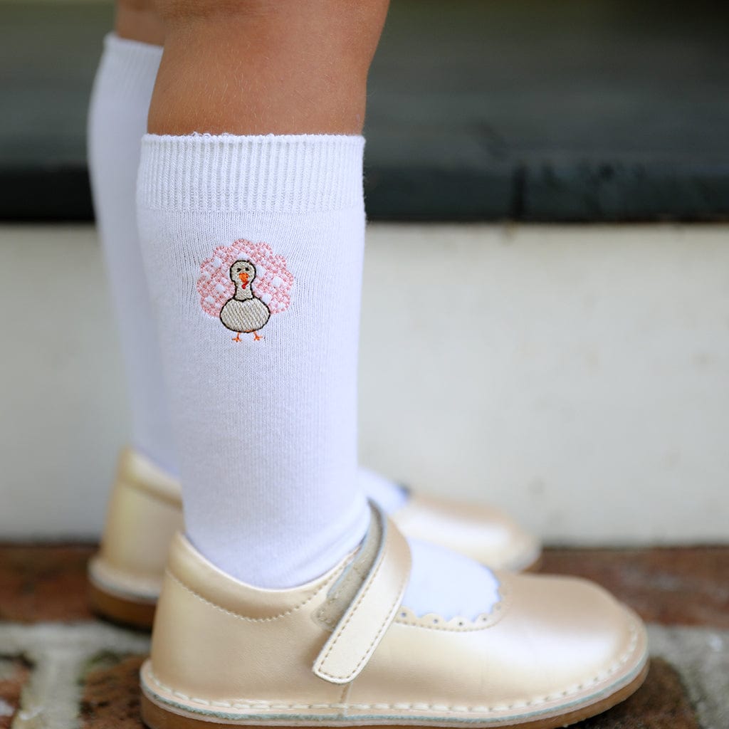 Child wearing white knee-high turkey socks